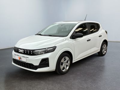 Une voiture blanche est garée dans une pièce au sol noir.
