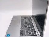 a silver laptop with a blue sticker on the keyboard