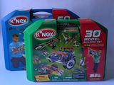 two boxes of k ' nex toys with a boy playing with a toy car