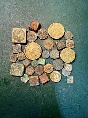 quelques vieilles pièces posées sur une table, à côté d'une pile de pièces plus petites