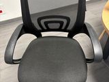 a black office chair with a gray seat and a wooden table