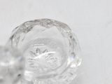 a clear glass object on a table with a white background
