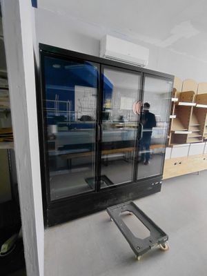 un homme qui se tient debout dans une pièce dont la porte est en verre