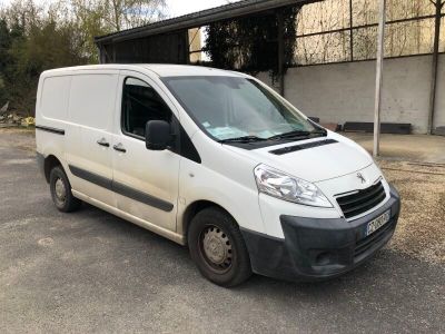 la camionnette blanche est garée devant un bâtiment dans un parking