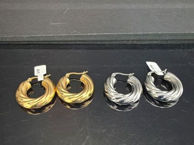 three pairs of gold and silver hoop earrings on a black surface
