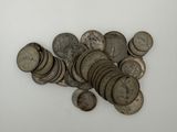une pile de vieilles pièces d'argent sur une surface blanche