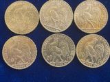 six different types of coins on a blue cloth
