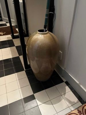 un vase posé par terre dans le couloir