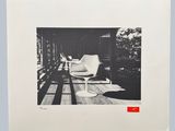 black and white photograph of a white chair on a wooden floor