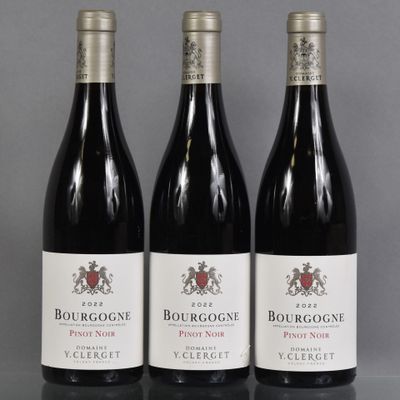 three bottles of red wine sitting on top of a table