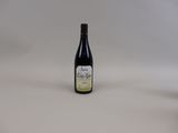 a bottle of wine sitting on top of a table next to a bottle of wine