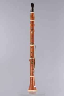 une clarinette en bois avec une partie supérieure noire et un corps blanc