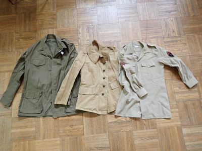 two jackets and a shirt sitting on a wooden floor next to each other