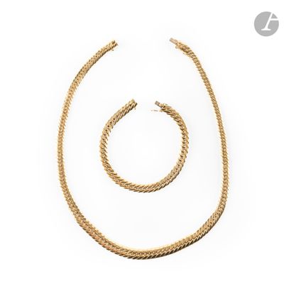 a gold necklace and bracelet set on a white background