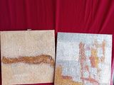 two pieces of art on a red cloth with a red background