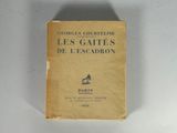 un vieux livre posé sur une table à côté d'un mur blanc