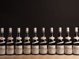 six bouteilles de vin sont alignées sur une table en bois