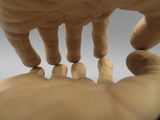a wooden sculpture of a hand holding a finger