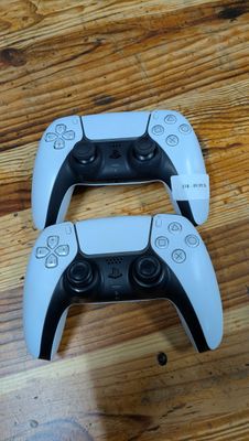 deux manettes de jeux vidéo posées sur un parquet