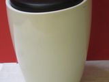 une tasse blanche avec un couvercle noir posée sur un plan de travail