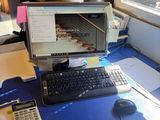 a desk with a computer, keyboard, mouse, and calculator on it