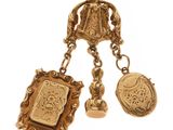 un gros plan sur un collier en or orné d'un fermoir et de deux breloques