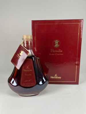 une image représentant une bouteille de brandy posée à côté d'une boîte rouge