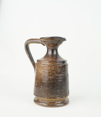 a brown vase with a handle on a white background