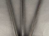 two metal tonges on a gray surface with a white background