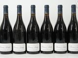 six bottles of wine are lined up in a row