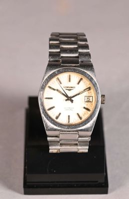 a silver watch with a white face on a black stand