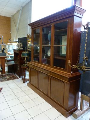 a display case in the middle of a room filled with antiques