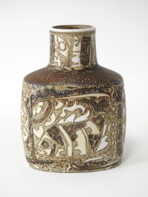 un vase brun et blanc posé sur une surface blanche