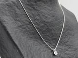 silver plated necklace with a diamond pendant on a mannequin torso