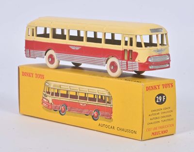 un petit bus jouet jaune et rouge posé sur une boîte jaune