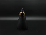 a gold ring with a black stone sits on top of a cone