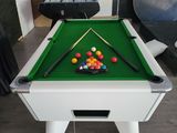 une table de billard avec des boules dessus, dans une pièce
