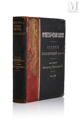 un vieux livre posé sur une table blanche à côté d'un livre noir