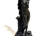 a bronze statue of a woman holding a flower pot