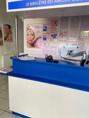 un comptoir bleu et blanc dans un magasin, avec des affiches accrochées au mur
