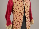 une veste rouge et dorée, parsemée de taches rouges