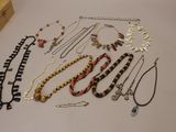 many necklaces and bracelets laid out on a table