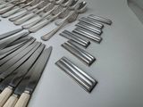 a lot of forks and spoons laid out on a table
