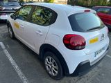 une voiture blanche garée dans un parking à côté d'autres voitures
