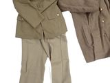 two military uniforms are displayed on a white surface