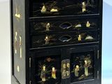 une commode noire surmontée de nombreux tiroirs
