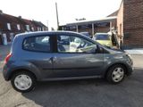 a small grey car parked on the side of the road