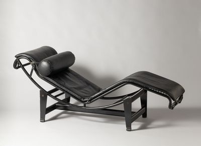 a black leather chaise lounger with a black leather cushion
