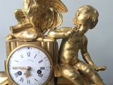 a gold clock with a statue of a boy and a rooster on top of it