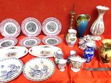 de nombreuses assiettes et vases posés sur une table recouverte d'une nappe rouge